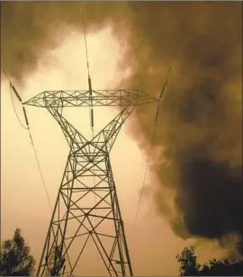  ?? Noah Berger Associated Press ?? PG&E officials say the forced outages were appropriat­e in an effort to keep people safe. Above, the Camp fire burns near power lines in Big Bend, Calif., in 2018.