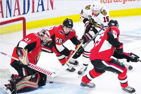  ?? SEAN KILPATRICK /CP FILES ?? Blackhawks centre Artem Anisimov battles Senators defenceman Max Lajoie and centre Matt Duchene in front of Ottawa netminder Craig Anderson last week in Ottawa. The new-look Senators have provided fans with edge-of-the-seat action early this season but will need to tighten up their defensive game as the season wears on, writes Ken Warren.