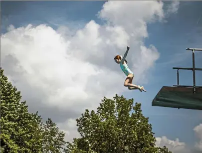  ?? Alexandra Wimley/ Post- Gazette ?? Abby Swank, 10, of Robinson, leaps off a diving board Thursday at Settlers Cabin Park in Robinson.