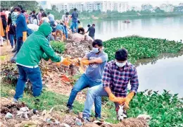  ?? — DC ?? As part of the Swachh internship programme by the GHMC, students take part in Hussainsag­ar lake cleaning activity on Monday. Plastic waste stuck on the banks of lake which is causing foul smell has been cleaned by the interns.