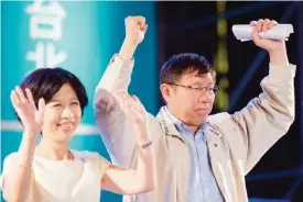  ??  ?? TAIPEI: Newly-elected independen­t Taipei mayor Ko Wen-je (right) and Hen Pei-chi gesture after winning the Taipei mayoral elections in Taipei yesterday. Taiwan’s premier resigned after his Beijing-friendly ruling party suffered a landslide defeat at...