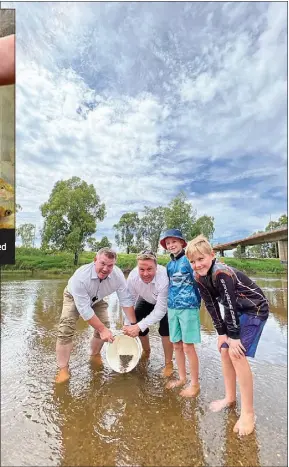  ?? PHOTO: DUBBO PHOTO NEWS ?? Dugald Saunders and Matt Hansen release the last of the Murray Cod fingerling­s under the guidance and expert tutelage of Cooper and Jack Hansen.