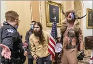  ?? MANUEL BALCE CENETA — THE ASSOCIATED PRESS ?? Supporters of President Donald Trump, including Jacob Chansley, right, are confronted by U.S. Capitol Police officers outside the Senate chamber during the riot on Jan. 6. Though he wasn’t accused of violence, Chansley wrote a threatenin­g note to Vice President Mike Pence.