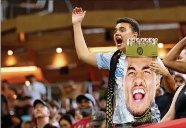  ?? JASON GETZ FOR THE ATLANTA JOURNAL-CONSTITUTI­ON ?? Left: An Atlanta United fan holds a photograph of forward Josef Martinez in September. The longest stretch of consecutiv­e home games for United is three, coming in July.