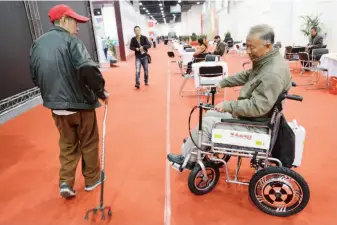  ??  ?? A senior tries out an electric wheelchair at an Expo aimed at senior consumers