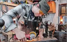  ?? SEAN D. ELLIOT/THE DAY ?? Brian Dimmock uses a grinder to make hinges for an armored gauntlet set in his Norwich workshop on Friday. Dimmock will appear in an episode of the History Channel competitio­n series “Forged in Fire” at 9 p.m. Tuesday.
