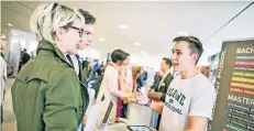  ?? RP-FOTO: ANNE ORTHEN ?? Barbara Blumenthal und ihr Sohn Niklas informiere­n sich bei Lucas Autor über das Studium an der Cologne Buisness School.