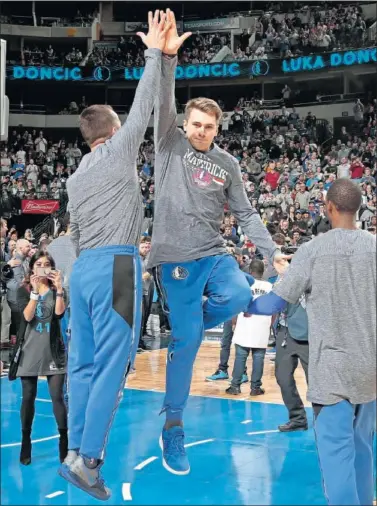  ??  ?? APOYO. Luka Doncic choca con JJ Barea en la presentaci­ón de los Mavericks antes de un partido.