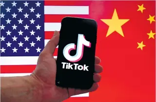  ?? PHOTO BY OLIVIER DOULIERY/AFP ?? n The social media applicatio­n logo for TikTok is displayed on an iPhone screen in front of a US flag and Chinese flag background in Washington, D.C., on March 16, 2023.