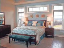  ??  ?? The master bedroom features a transom window above the bed and windows on both sides.