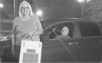  ?? LUIS SANTANA/TAMPA BAY TIMES ?? Marie Woody and her husband, Jerry, with a cooler containing a cornea specimen outside of the Lions Eye Institute in Tampa, Florida. They have driven across Florida to deliver thousands of donated corneas.