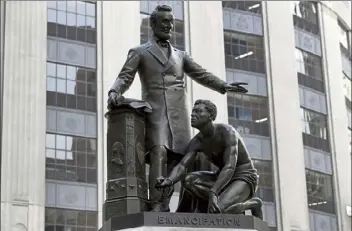  ?? Steven senne / ap ?? a statue that depicts a freed slave kneeling at president abraham lincoln's feet rests on a pedestal in boston on June 25. on tuesday, the statue that drew objections amid a national reckoning with racial injustice was removed from its perch.