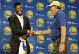  ?? Associated Press ?? Golden State Warriors NBA basketball draft pick Jordan Bell, left, shakes hands with broadcaste­r Jim Barnett at a news conference Friday in Oakland, Calif.