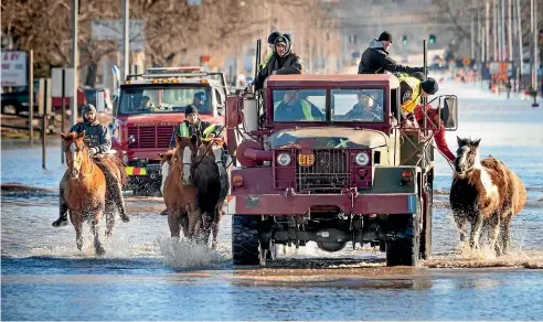  ?? AP ?? Rescue takes all forms as the flood waters rise in Inglewood, Nebraska.