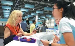  ?? WANG ZHUANGFEI / CHINA DAILY ?? A volunteer responds to a US reporter’s questions in the media center at the G20 Summit venue on Thursday. The center opened on Thursday.