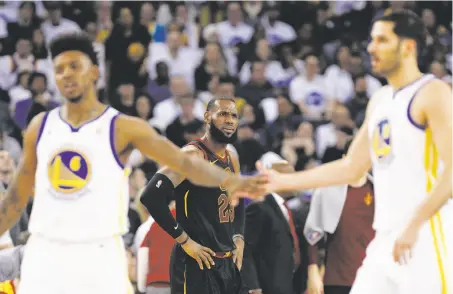  ?? Carlos Avila Gonzalez / The Chronicle ?? James, bracketed by the Warriors’ Nick Young (left) and Omri Casspi, reacts after a call didn’t go his way in the first half.