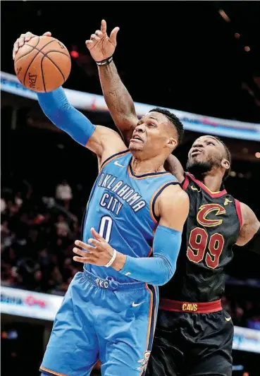  ?? [AP PHOTO] ?? Oklahoma City’s Russell Westbrook grabs a rebound in front of Cleveland’s Jae Crowder during Saturday’s game in Cleveland. The Thunder cruised to a 148-124 victory.