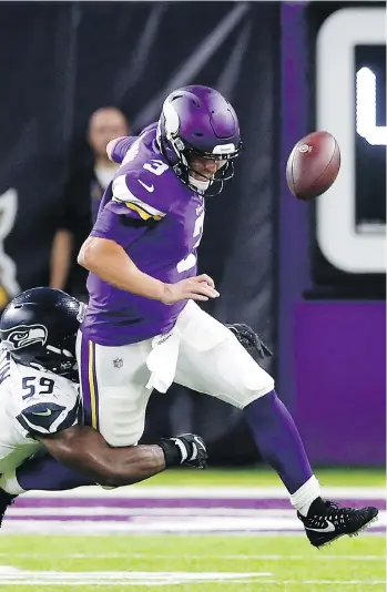  ?? JIM MONE/THE ASSOCIATED PRESS ?? Vikings quarterbac­k Trevor Siemian fumbles as he is tackled by Seattle Seahawks defensive end Jake Martin during the second half of an NFL pre-season game Friday in Minneapoli­s.