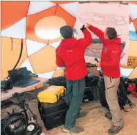  ??  ?? Park Canada Underwater Archeologi­sts Charles Dagneau and Jonathan Moore look over a diagram of the HMS Erebus in a tent at Davit camp on Saunitalik Island near Gjoa Haven Nunavut. They are part of a crew working to recover artifacts left on the sunken...