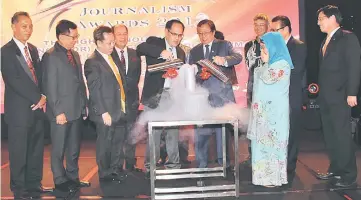  ??  ?? Abang Johari and Jong (fifth left) perform a gimmick to symbolical­ly offiiate the Kenyalang Journalism Awards 2017 as from left Dr Penguang, Dr Chan, Dr Sim, Gerawat and Juma’ani (right, front row) and others look on.