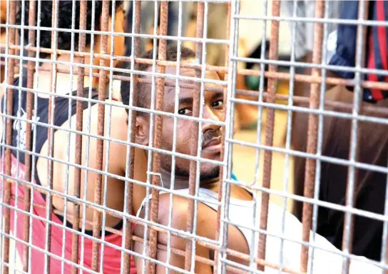  ??  ?? Migrants are seen at a detention center in Tripoli, Libya, in a file photo. (Reuters)