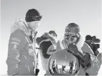  ??  ?? Prince Harry, left, and U.S. team’s Ivan Castro touch the South Pole marker, which the Walking With the Wounded reached Friday.