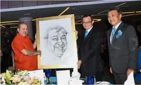  ??  ?? Royal gift: Fu (second from right) presenting a portrait as a gift to Sultan Ibrahim while Wong looks on during the StarProper­ty.my Awards 2018 in Johor Baru.