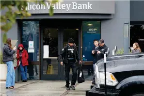  ?? The Associated Press ?? ■ A Brinks worker walks toward a truck Friday after exiting Silicon Valley Bank in Santa Clara, Calif. The U.S rushed to seize the assets of Silicon Valley Bank on Friday after a run on the bank, the largest failure of a financial institutio­n since Washington Mutual during the height of the financial crisis more than a decade ago.