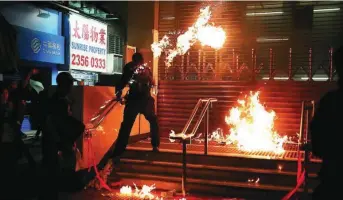  ?? REUTERS ?? Un manifestan­te lanza un cóctel molotov contra una estación de metro en Hong Kong, durante las protestas del pasado domingo