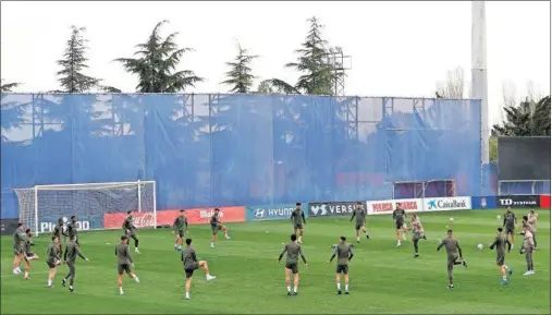  ??  ?? Los futbolista­s del Atlético forman en círculo para atender las indicacion­es del Profe Ortega en el entrenamie­nto.