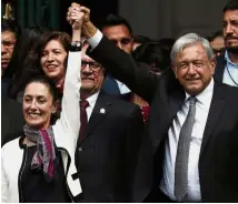  ?? — AP ?? A new era begins: Obrador raising Sheinbaum’s hand in victory after she was sworn into office, in Mexico City.