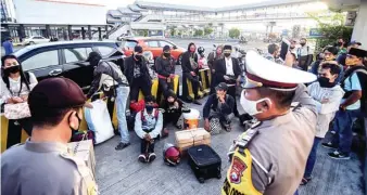  ?? RAMADA KUSUMA/ JAWA POS RADAR BANYUWANGI ?? ILEGAL: Penumpang travel pelat hitam dari Bali diminta turun oleh anggota satlantas di pintu keluar Pelabuhan Ketapang kemarin.