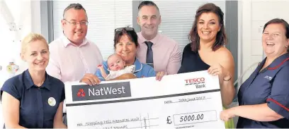  ??  ?? ●●Mike and Rosie Griffin and daughter Lola present the a cheque for £5,000 to staff at Stepping Hill Hospital’s neonatal unit Andy Lambert