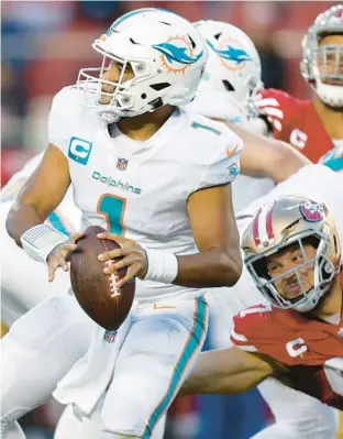  ?? JED JACOBSOHN/AP ?? Dolphins quarterbac­k Tua Tagovailoa looks to pass before 49ers defensive end Nick Bosa caused Tagovailoa to fumble on Dec. 4.
