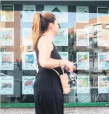  ?? ?? Una mujer pasa frente a una inmobiliar­ia.