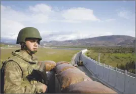  ?? AP PHOTO ?? A Turkish army soldier mans an outpost near the town of Kilis, southeaste­rn Turkey, adjacent to the wall the country had been constructi­ng to boost security along its border with conflict-stricken Syria.