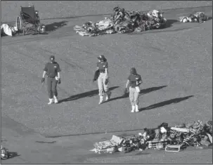  ?? The Associatd Press ?? SHOOTING SCENE: Members of the FBI walk among piles of personal items at the scene of a mass shooting Friday in Las Vegas. Stephen Paddock opened fire on an outdoor music concert on Sunday killing dozens and injuring hundreds.