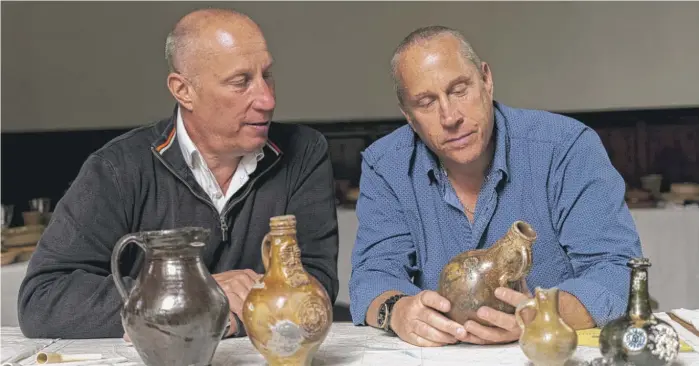  ?? UOEA VIA AP ?? Julian And Lincoln Barnwell look at artifacts they found on the wreck of the HMS Gloucester in 2007. The wreck was firmly identified in 2012 and only made public on Friday.