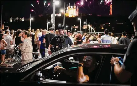  ?? Laurent Cipriani/Associated Press ?? Police control a driver as people gather to watch Bastille Day fireworks on July 14 in Lyon, France. The national holiday was marked with a grand Bastille Day parade in Paris but also 130,000 police officers around the country to prevent a new outbreak of unrest.