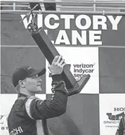  ??  ?? IndyCar driver Josef Newgarden holds up the trophy after winning the Honda Indy Grand Prix of Alabama on Monday. BUTCH DILL/AP