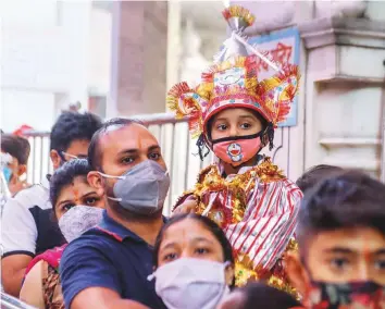  ?? AFP ?? A child dressed up like Hindu God Hanuman is carried by a man while visiting Bara Hamuman Temple during the Hindu festival ‘ Navrati’ in Amritsar yesterday.