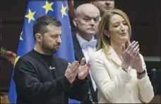  ?? AP PHOTO/OLIVIER MATTHYS ?? Zelenskyy and Roberta Metsola, the president of the European Parliament, applaud during the summit Thursday in Brussels.