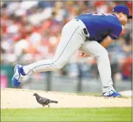  ?? Nick Wass / Associated Press ?? A bird stands by the mound as New York Mets starting pitcher Corey Oswalt follows through on a pitch during the third inning against the Washington Nationals on Saturday in Washington.