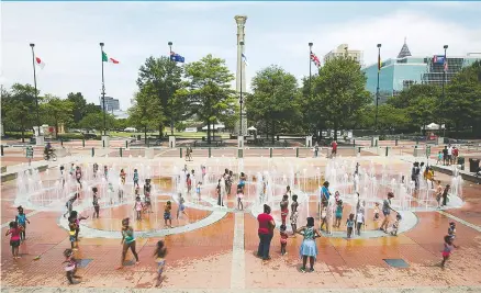  ?? ASSOCIATED PRESS PHOTOS ?? People play in the fountains shaped by the Olympic rings at Centennial Olympic Park in Atlanta recently. This was the hub of the games, a gathering spot for sponsor tents and nightly concerts. Tragedy struck midway through the Olympics when a deadly...