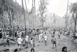  ?? Associated Press file photo ?? Hundreds of Guam residents pour into the Agana refugee camp in August 1944. More than 75 years later, thousands are expecting long-awaited compensati­on.