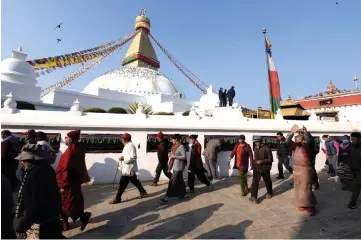  ??  ?? Nepali police stand guard as Tibetans walks past the Bouddhanat­h Stupa in Kathmandu, on the 60th anniversar­y of the 1959 Tibetan uprising against Chinese rule. — AFP photo