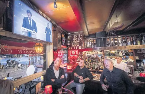  ?? AFP ?? People watch a broadcast of a press conference of the Dutch prime minister and health minister on new measures taken to tackle the spread of the Covid-19 pandemic in Amsterdam, the Netherland­s yesterday.