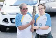  ??  ?? Golden day Flashback to 2014 in Kippen and Niall Finlayson hands the Queen’s Baton to Graham Eadie