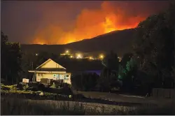  ?? CP PHOTO/DARRYL DYCK ?? A wildfire burns on a mountain behind an RV park office in Cache Creek, B.C., in the early morning hours of Saturday. B.C. government officials now estimate that 7,000 people have been evacuated from their homes due to wildfires burning in the...