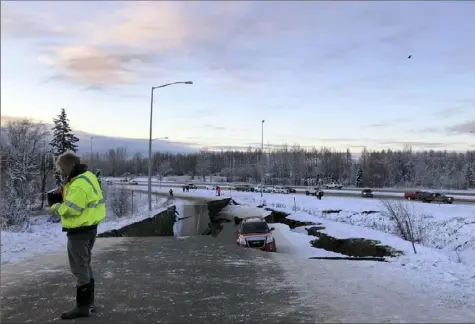  ?? Dan Joling/Associated Press ?? A car is trapped Friday on a collapsed section of the off-ramp of Minnesota Drive in Anchorage, Alaska.